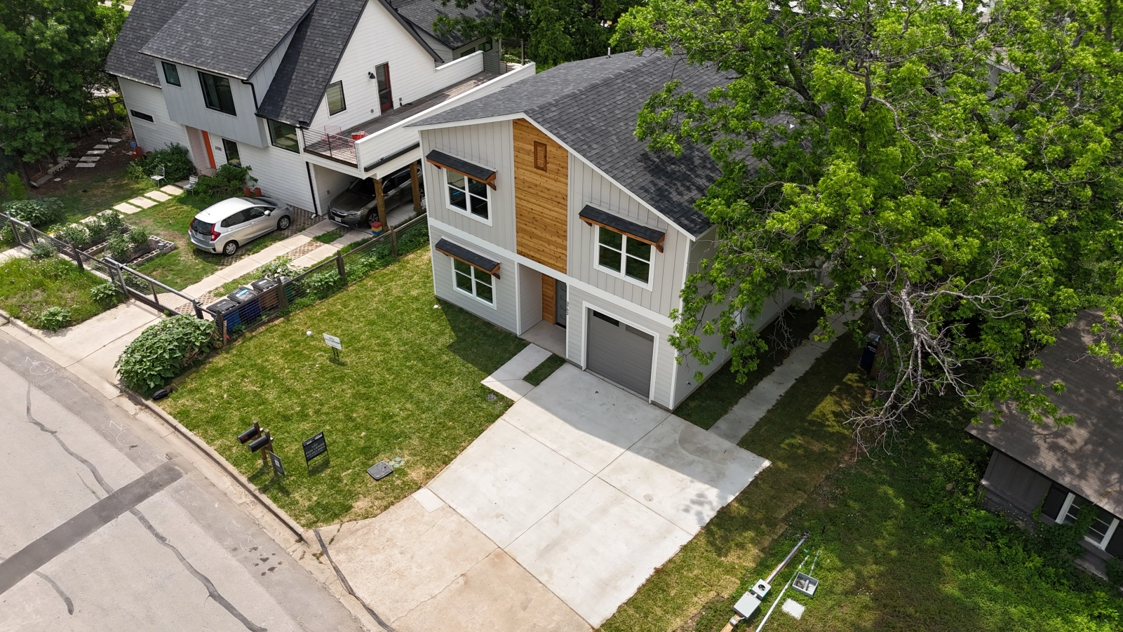 Aerial view of Towerview Dwelling beside an existing home, driveway, mature tree, and neighboring structures