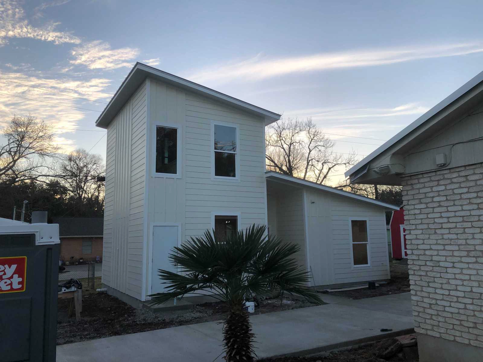 N Bishop ADU beside an existing Austin home, showing building separation, side access, and neighboring context