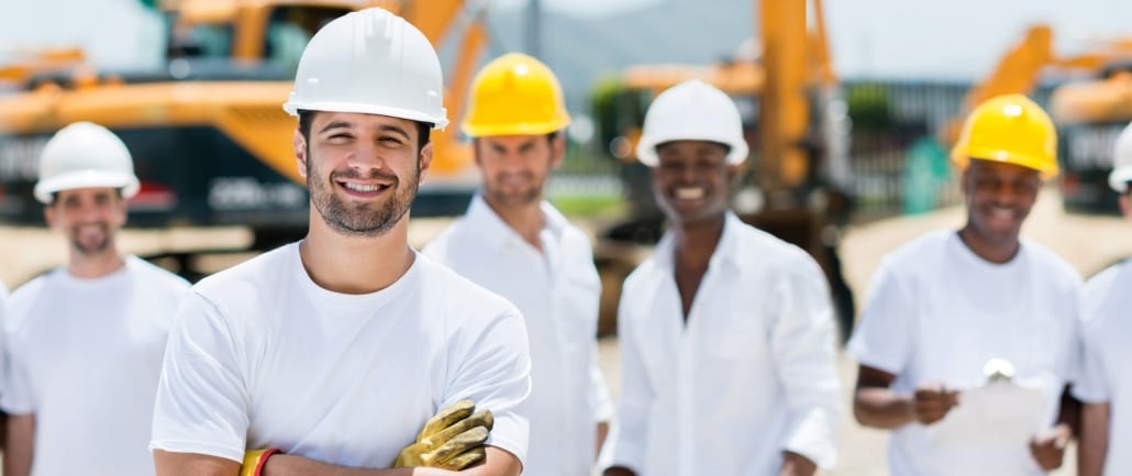 A group of construction workers standing in front of a custom home construction site.